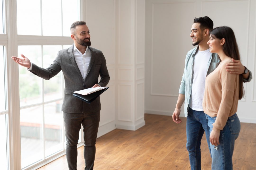 Estate agent showing property to young buyers